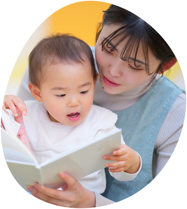 大人と一緒に本を読みながら学ぶ子ども